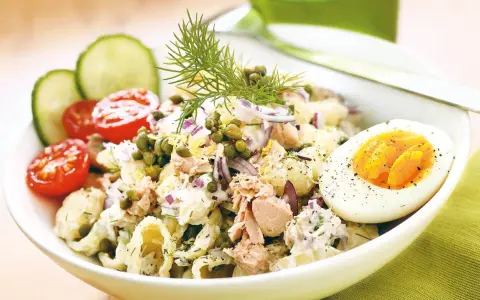 En härlig tonfisksallad med pasta, toppad med kapris, rödlök och dill. Serveras med halvt kokt ägg och körsbärstomater.