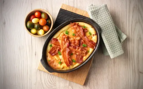 En härlig ugnspannkaka med knaprigt bacon, serverad med en skål körsbärstomater. Perfekt för en mysig frukost eller brunch.