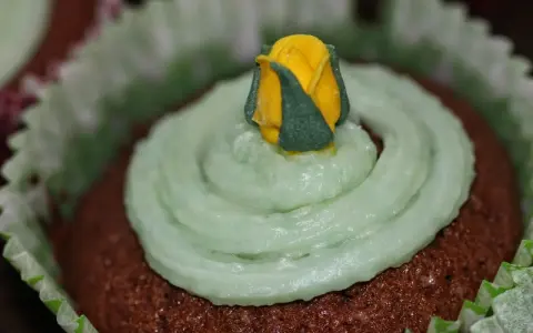 Chokladmuffins med ljusgrön frosting och en gul ros. Ett enkelt frosting recept för dekoration.
