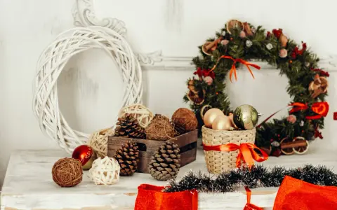 Jul inredning inspiration: en vit flätad krans, julgranskulor, kottar och en grön julkrans med torkad frukt.