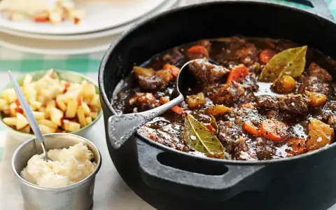 En mustig kalops i gjutjärnsgryta, med morötter och lagerblad. Serveras med äppelkompott och potatismos. Ett klassiskt kalops recept.