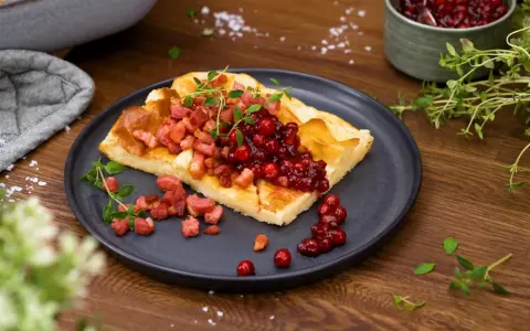 En bit ugnspannkaka med knaperstekt bacon och rårörda lingon. Ett klassiskt recept på ugnspannkaka som passar perfekt till middag.