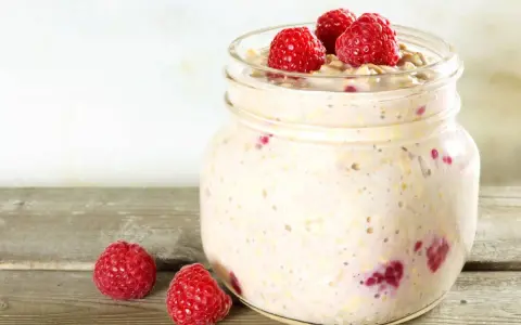 Overnight oats med proteinpulver och hallon i burk, perfekt för en snabb och näringsrik frukost.