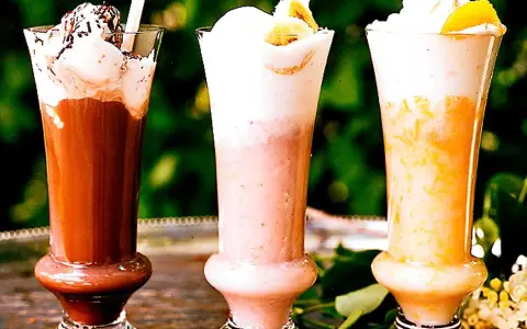 Tre läckra milkshakes i glas: choklad, jordgubb och aprikos. Perfekt för ett somrigt milkshake recept!