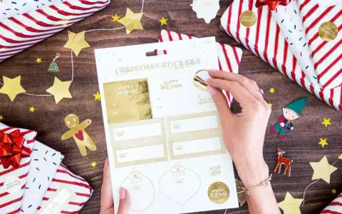 Julklappar inslagna med stjärnor och tomtar. En hand väljer julklappsdekaler, perfekta för julrim barn.
