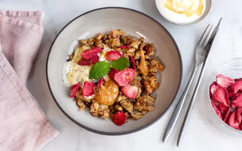 En skål med krämig yoghurt, krispig granola, jordgubbar och en klick jordnötssmör. En perfekt start på dagen med scrambled oats!