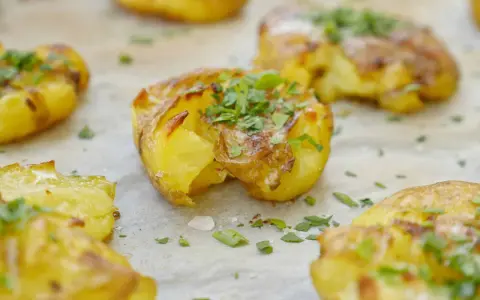 Krispiga, gyllene smashed potatis toppade med färsk persilja. Perfekt som tillbehör till middagen.