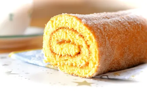 En sockerströdd rulltårta, perfekt för ett enkelt rulltårta recept.