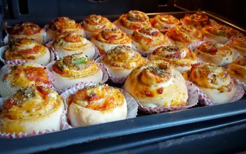Nybakade pizzabullar med ost och grönsaker, redo för ugnen. Ett perfekt pizzabullar recept för hela familjen.