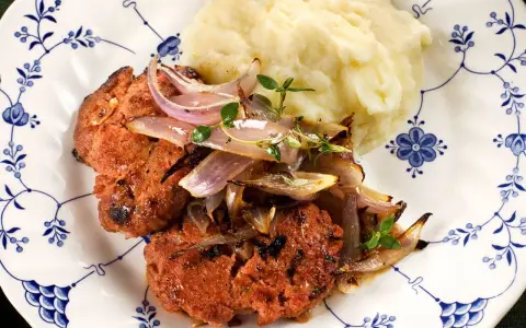 En saftig pannbiff i ugn, toppad med karamelliserad lök och en klick krämigt potatismos. En klassisk svensk rätt som värmer själen.