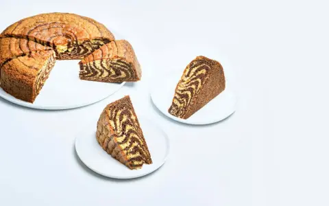 En saftig tigerkaka, skuren i bitar, visar upp sitt vackra marmorerade mönster. Ett perfekt tigerkaka recept för fikat.