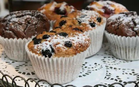 Färska muffins med blåbär och choklad, pudrade med florsocker. Perfekt för ett enkelt muffins recept.