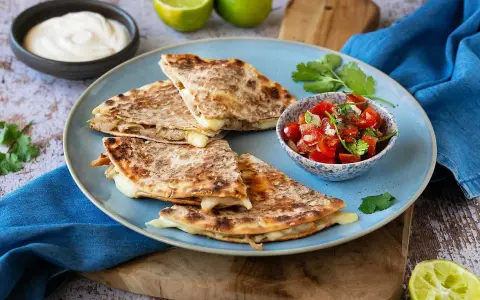 Här är ett läckert quesadillas recept! Krispiga quesadillas med smält ost, serverade med salsa, gräddfil och lime.
