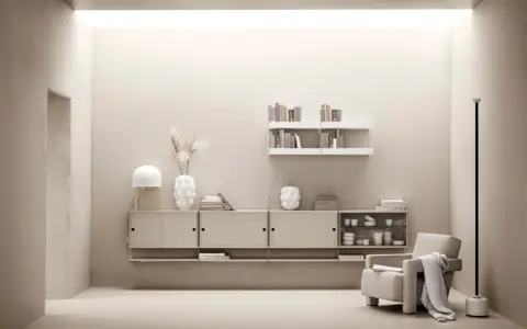 Minimalist livingrum med stringhylla inspiration. En beige fåtölj med pläd, lampa, vas och böcker på hyllor.