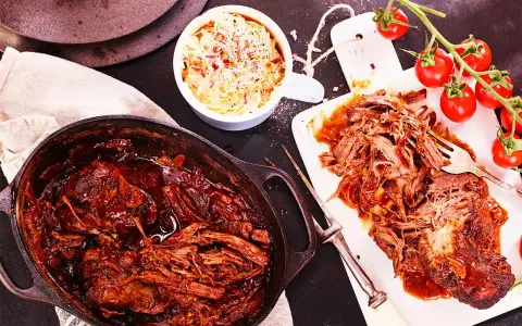 Saftigt pulled beef i en gjutjärnsgryta, serverat med krispig coleslaw och färska tomater. Perfekt för en mysig middag.