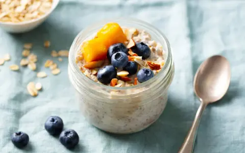 Overnight oats med mango, blåbär och mandel i ett glas. En perfekt start på dagen!