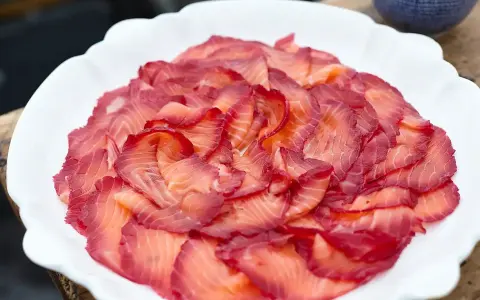 Vackert upplagd gravad lax på en vit tallrik. Perfekt för ett svenskt midsommarfirande eller som en del av ett gravad lax recept.