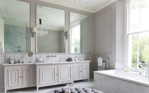 Ett lyxigt badrum med marmor, dubbla handfat, stor spegel och ett badkar. Perfekta inredningstips badrum för en elegant känsla.