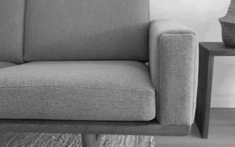 Grå soffa med trästomme, ett exempel på tidlös design möbler second hand.