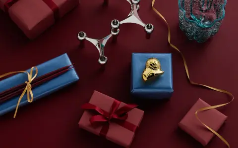 Julklappar i olika färger och en ljusstake. Perfekt inredning för julen.