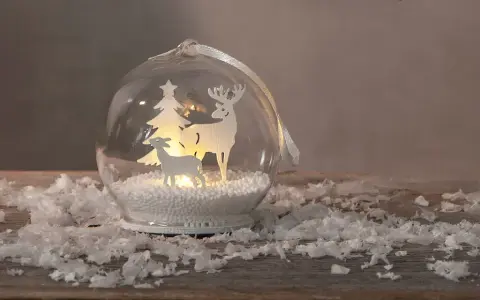 Jul inspiration: en glaskula med renar och gran, omgiven av snö.