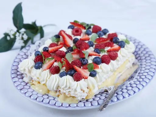 En vacker jordgubbstårta med grädde, bär och vaniljkräm. Perfekt för ett sommarfika, här är ett enkelt jordgubbstårta recept.