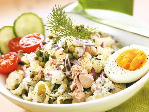 En härlig tonfisksallad med pasta, toppad med kapris, rödlök och dill. Serveras med halvt kokt ägg och körsbärstomater.