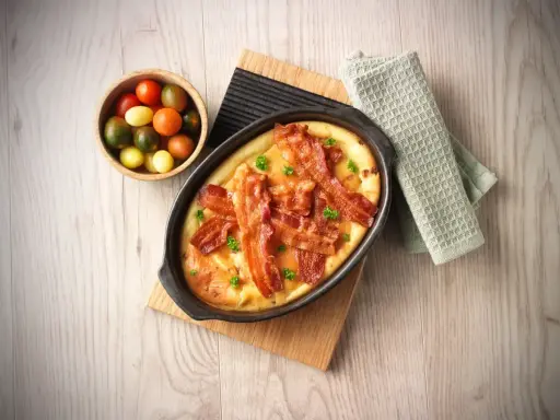 En härlig ugnspannkaka med knaprigt bacon, serverad med en skål körsbärstomater. Perfekt för en mysig frukost eller brunch.