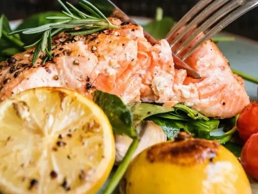Saftig lax med citron och rosmarin, perfekt för ett enkelt lax recept. Serveras med körsbärstomater och gröna blad.