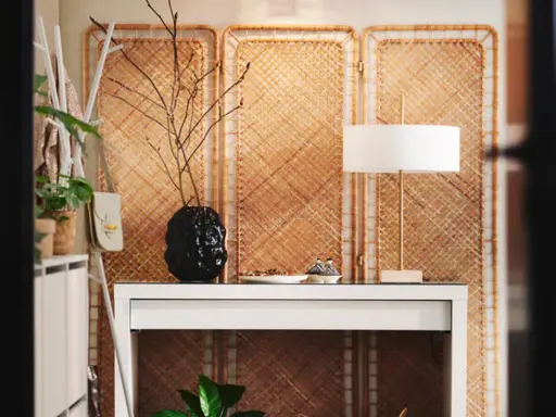 Skapa en mysig atmosfär och designa ditt rum med en vit hylla, en svart vas med grenar och en stilren lampa.