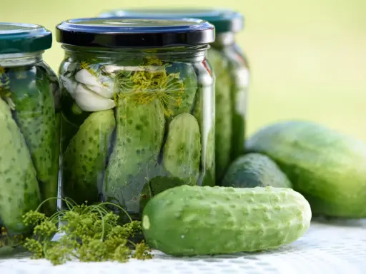 Burkar med inlagda gurkor, vitlök och dill. Perfekt för ett gott saltgurka recept.