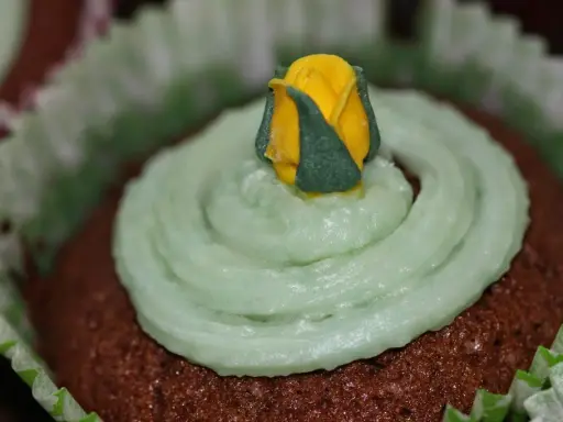 Chokladmuffins med ljusgrön frosting och en gul ros. Ett enkelt frosting recept för dekoration.
