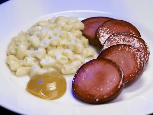 En tallrik med stuvade makaroner snabbt vis, skivad falukorv och en klick senap. En klassisk svensk rätt som är enkel att laga.