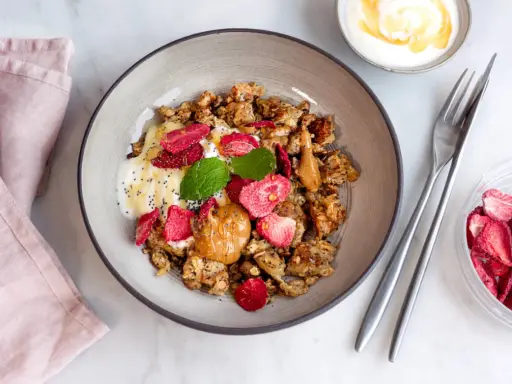 En skål med krämig yoghurt, krispig granola, jordgubbar och en klick jordnötssmör. En perfekt start på dagen med scrambled oats!