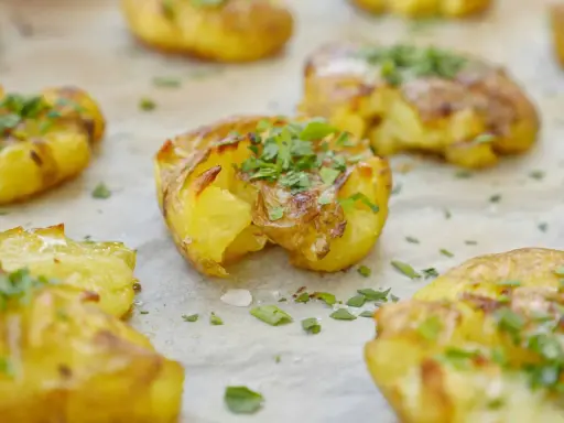 Krispiga, gyllene smashed potatis toppade med färsk persilja. Perfekt som tillbehör till middagen.