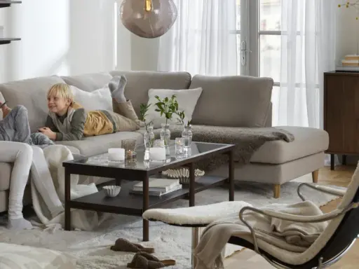 Familj myser i soffan. För att skydda tyget och göra det lättare att rengöra, kan man impregnera soffan.