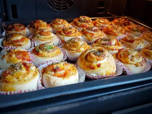 Nybakade pizzabullar med ost och grönsaker, redo för ugnen. Ett perfekt pizzabullar recept för hela familjen.