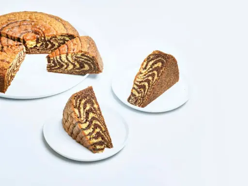 En saftig tigerkaka, skuren i bitar, visar upp sitt vackra marmorerade mönster. Ett perfekt tigerkaka recept för fikat.