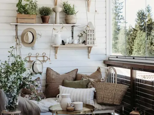 Mysig balkongdesign med kuddar, växter och en korgväska. En perfekt plats för avkoppling.