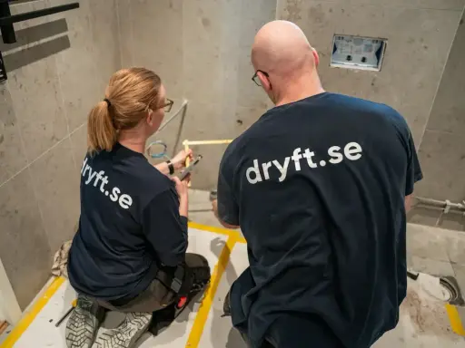 Två hantverkare från dryft.se mäter upp för att byta kommod i ett badrum.