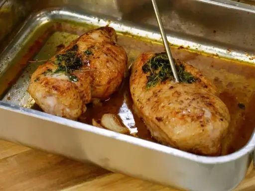 Två saftiga kycklinglårfiléer i ugnsform, en termometer visar att de är klara. Perfekt för ett gott kycklinglårfile recept.