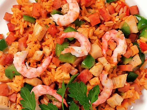 En närbild av en läcker jambalaya med ris, räkor, kyckling, korv och paprika. Perfekt för ett jambalaya recept!