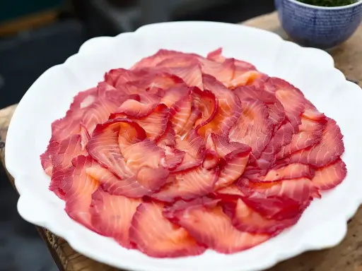 Vackert upplagd gravad lax på en vit tallrik. Perfekt för ett svenskt midsommarfirande eller som en del av ett gravad lax recept.