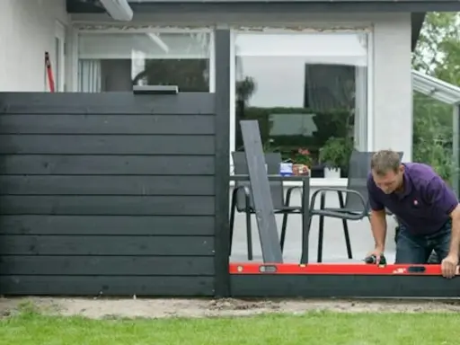 Man bygger ett modernt vindskydd till altanen. Inspiration för ditt eget utomhusprojekt.