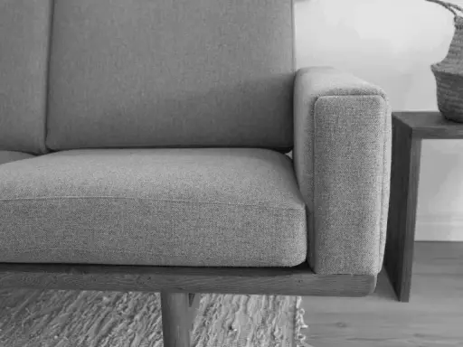 Grå soffa med trästomme, ett exempel på tidlös design möbler second hand.