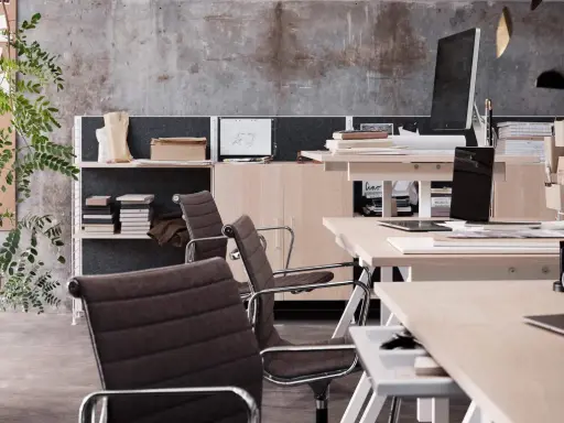 En modern arbetsplats med stolar, skrivbord, datorer och växter. En inspirerande miljö för kreativt arbete.