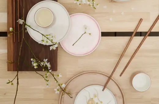 Vårens inspiration: tallrikar, ätpinnar och körsbärsblommor på träbord.