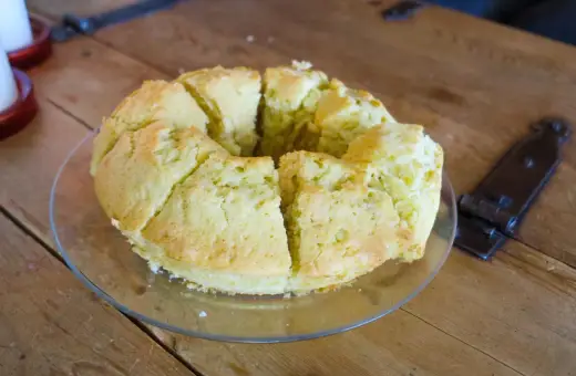 En saftig sockerkaka, uppskuren i bitar på ett fat, ligger på ett rustikt träbord.