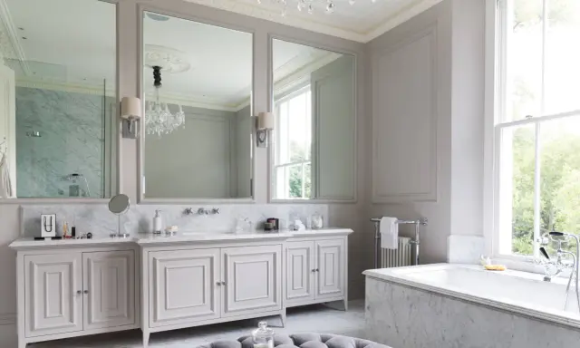 Ett lyxigt badrum med marmor, dubbla handfat, stor spegel och ett badkar. Perfekta inredningstips badrum för en elegant känsla.
