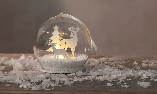 Jul inspiration: en glaskula med renar och gran, omgiven av snö.